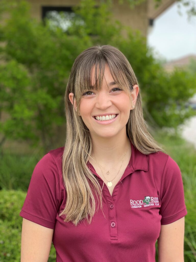 A woman in a red shirt smiling for the camera.