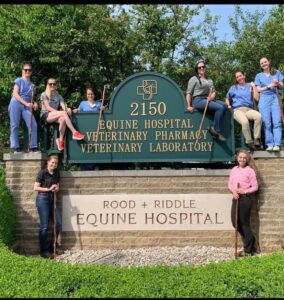 A group of people standing in front of a sign.