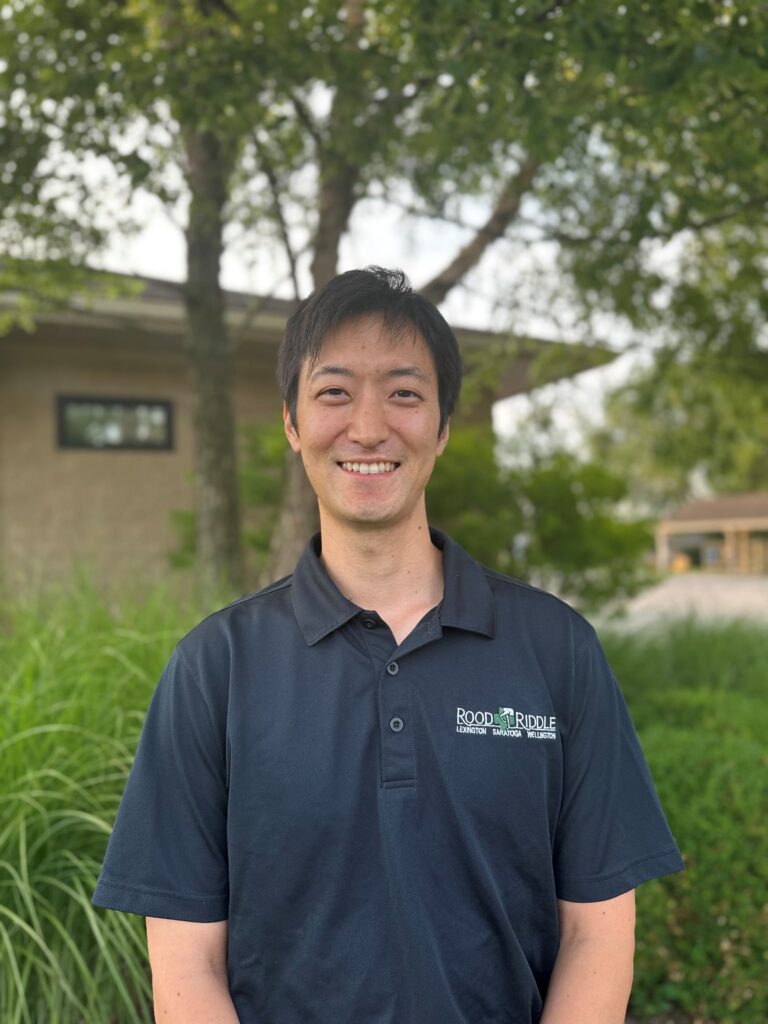 A man standing in front of some trees