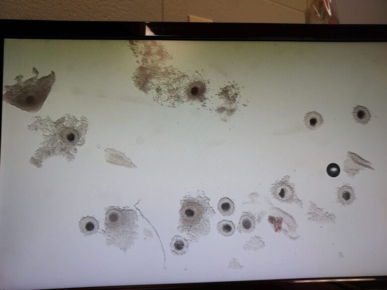 A tv screen with bullet holes and other things on it